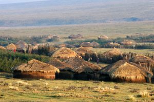 figure (a) shows grass huts 