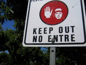 A keep out sign with text in English and Spanish is shown.